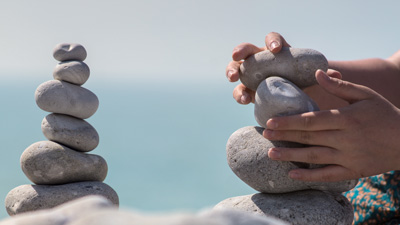 person patiently balancing stones