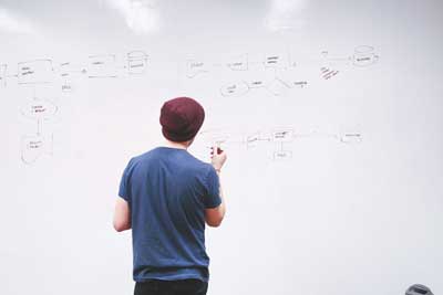 man writing in white board